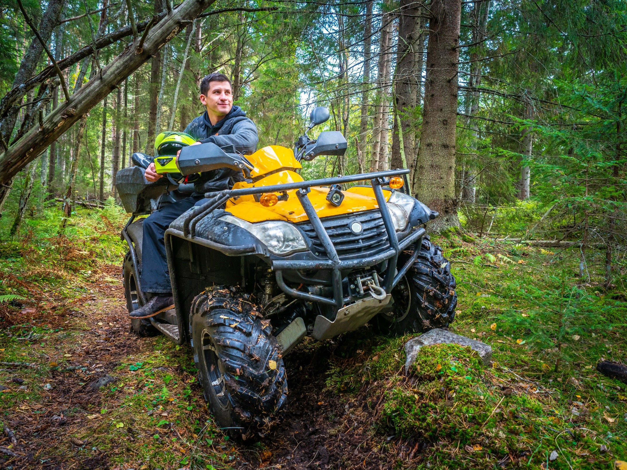 Man sitting on ATV in forest